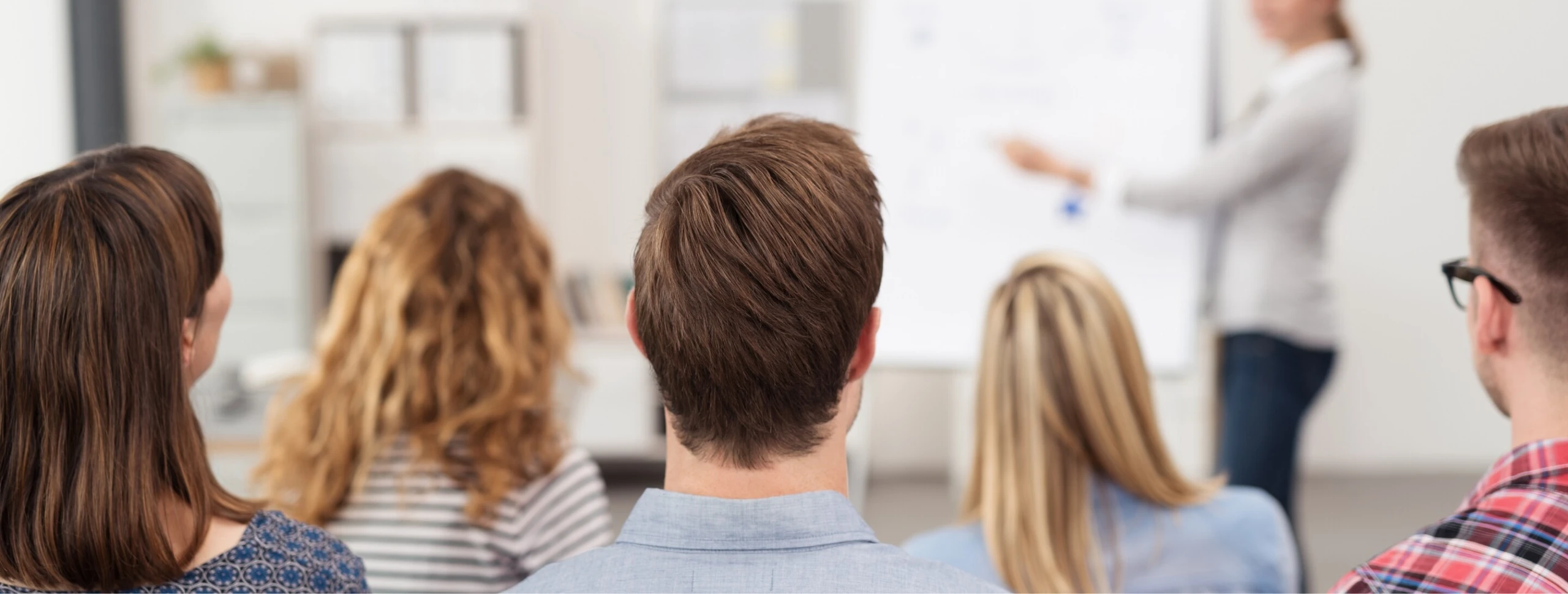 Lehrgangsteilnehmer:innen und eine Dozentin